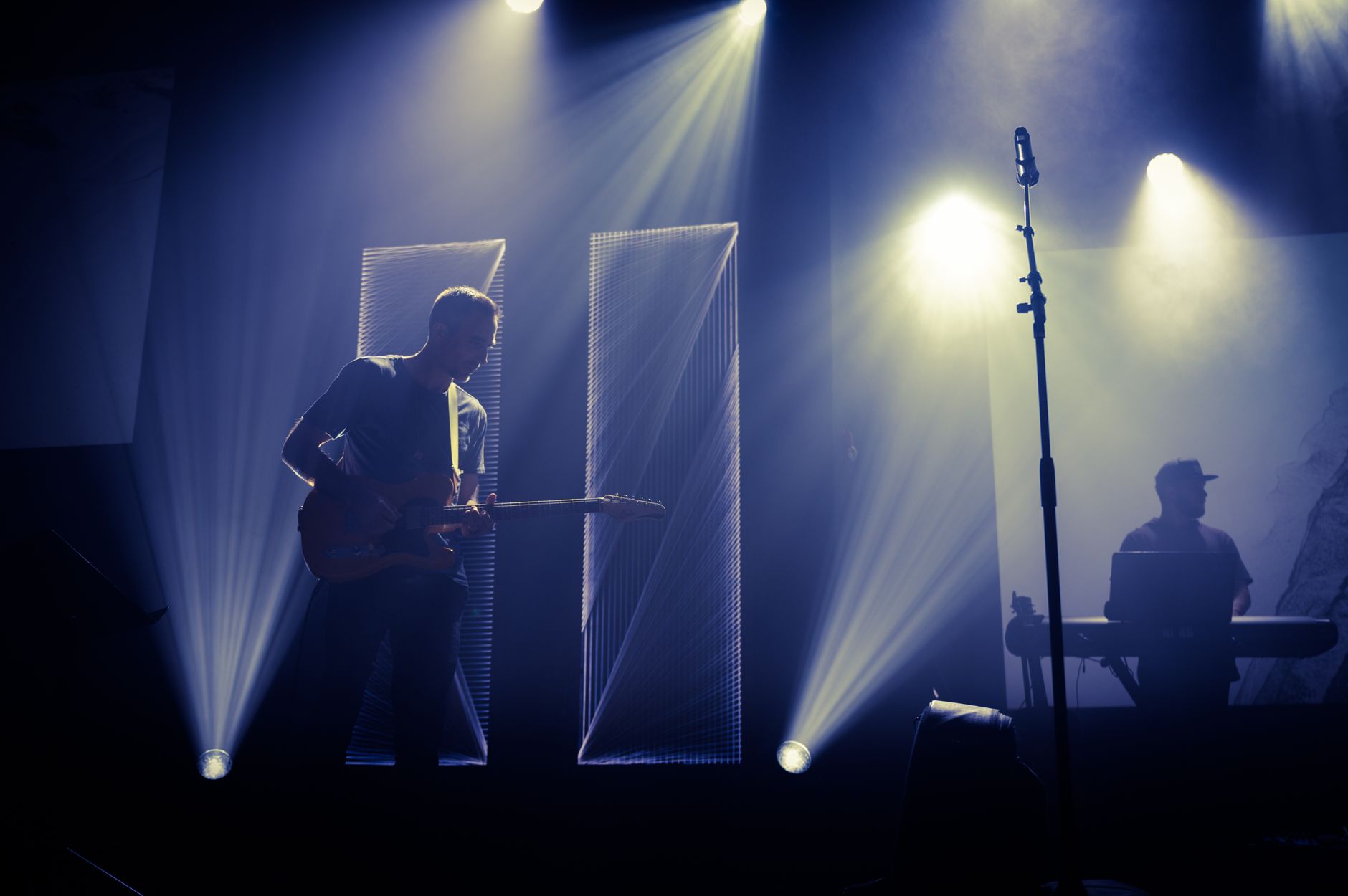 Band performing on a stage under colored lights
