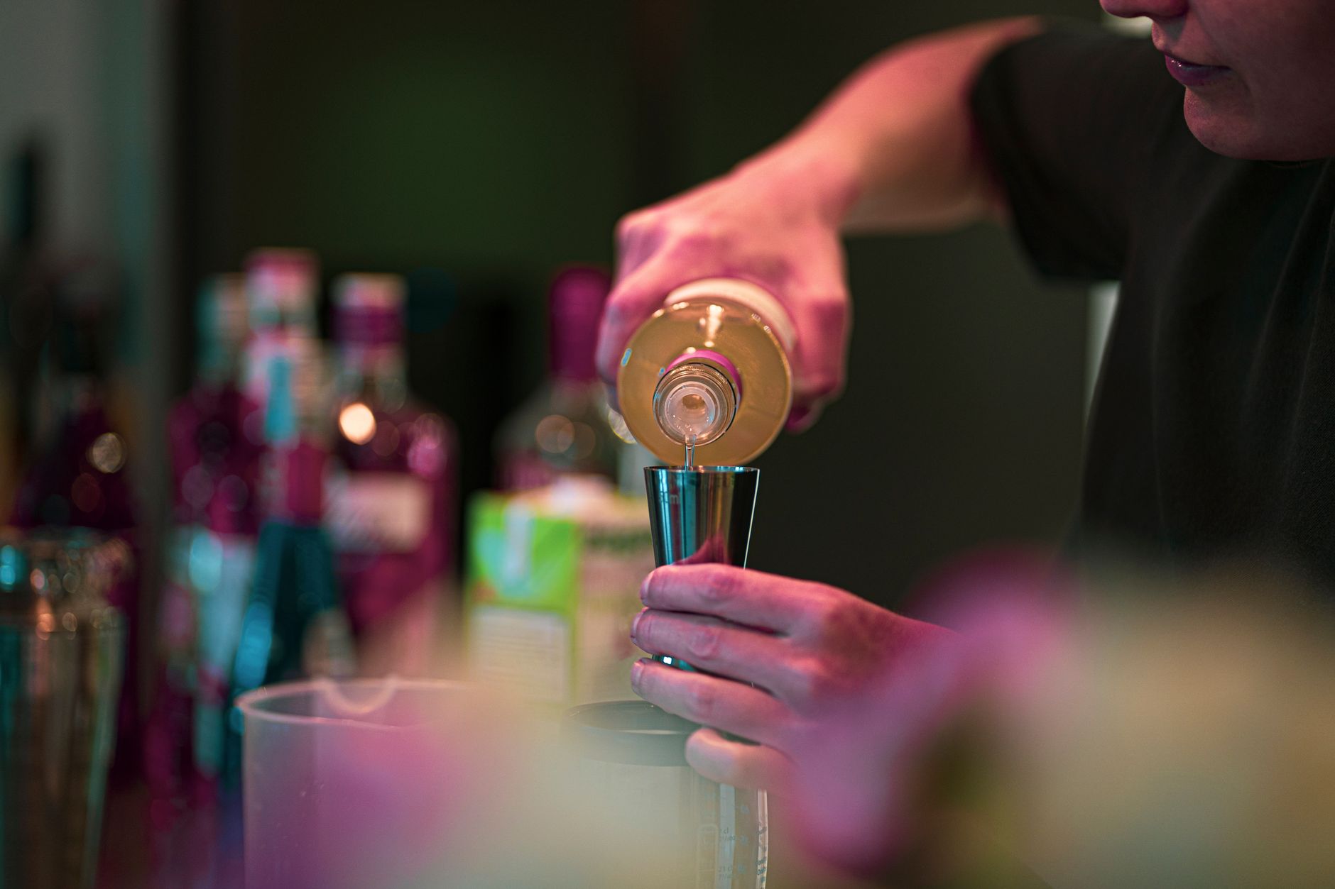 Bartender mixing a cocktail at a dimly lit bar
