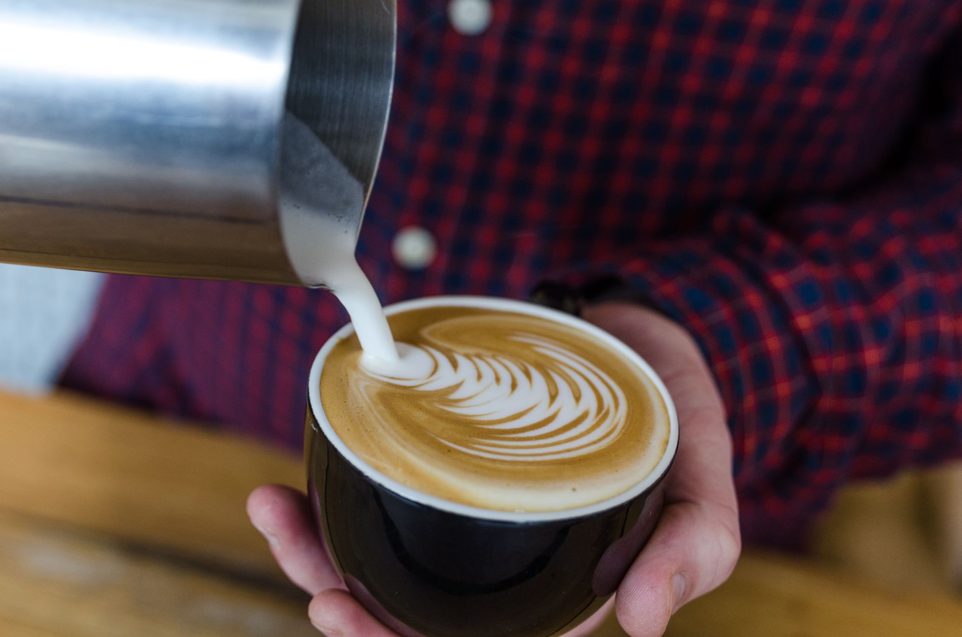 Barista pouring latte art in a coffee shop