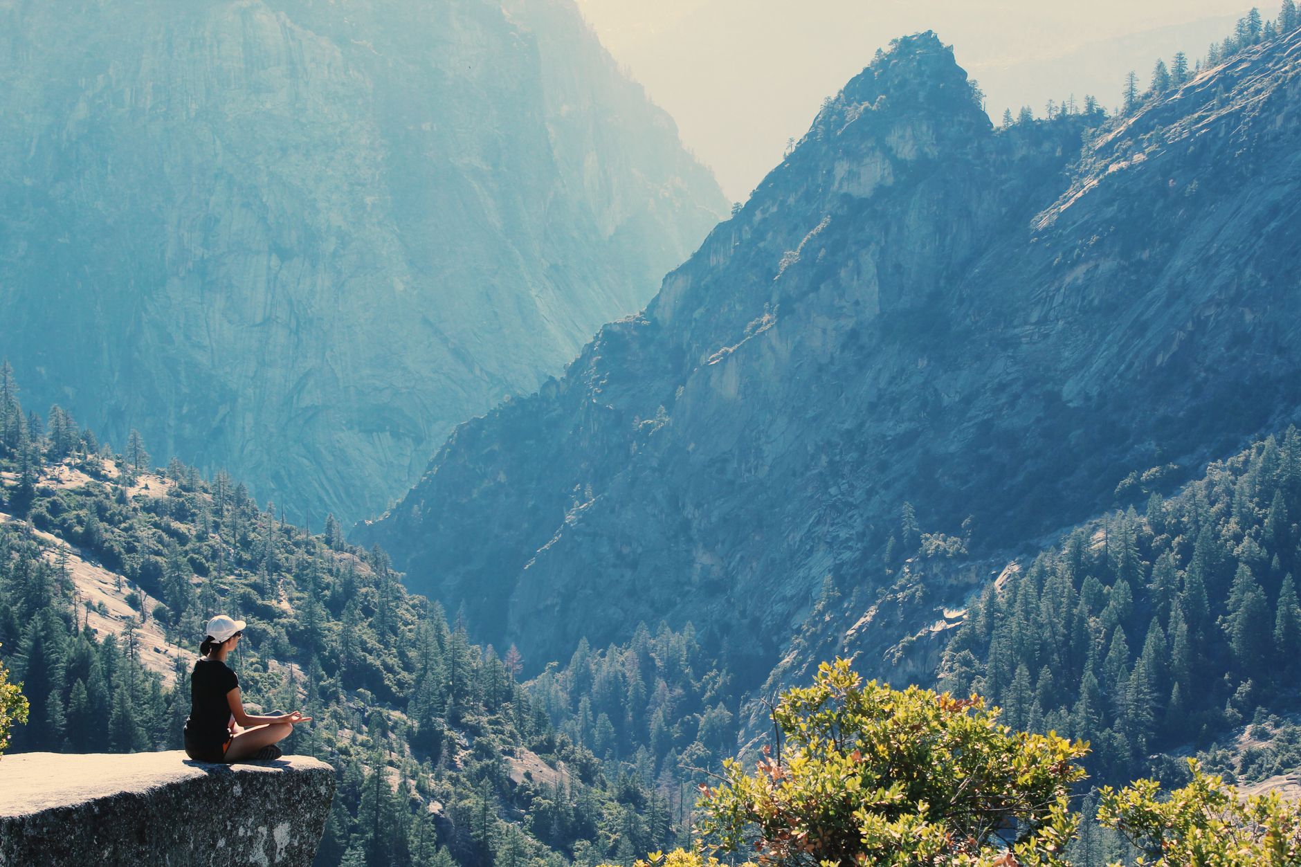 Meditating on a cliff edge above the mountains