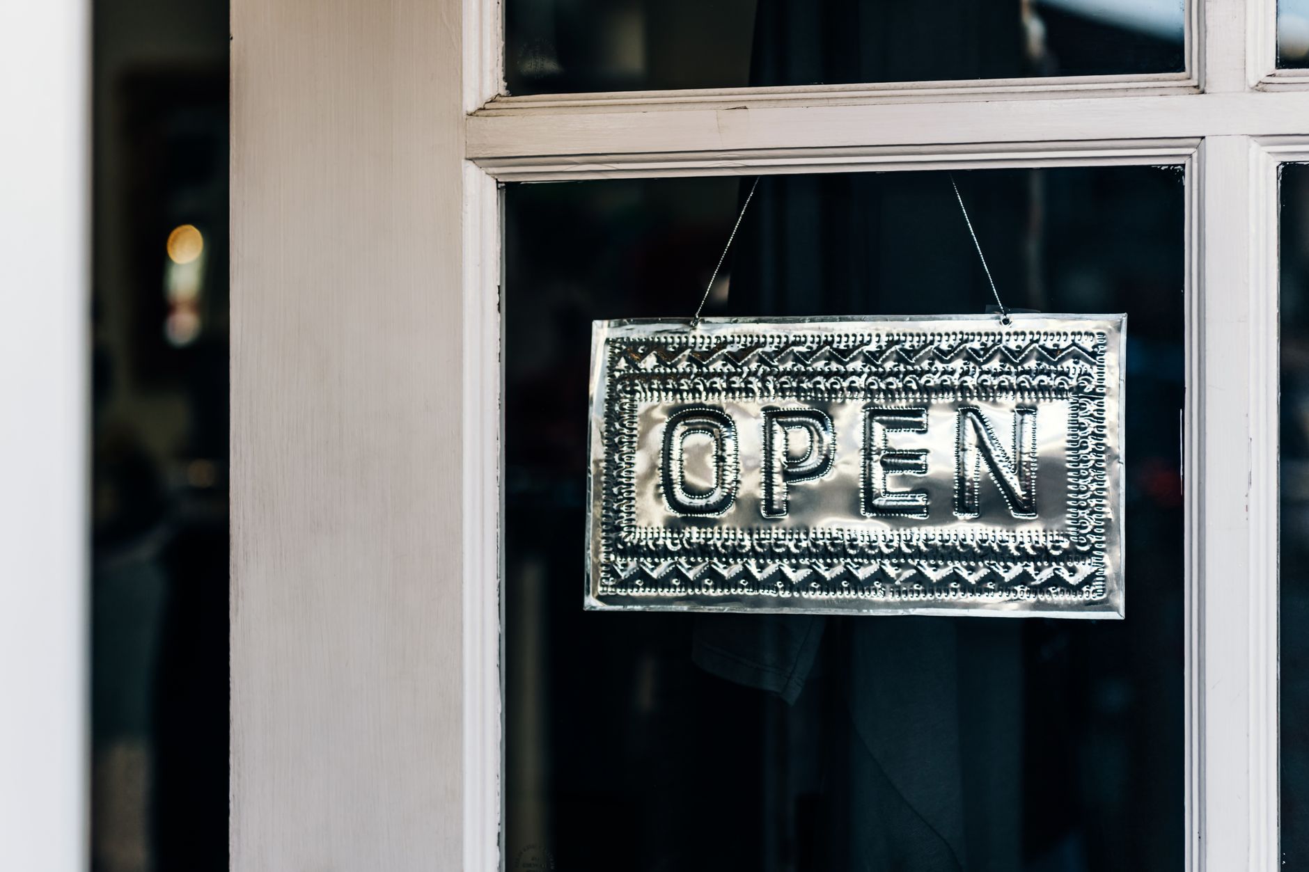 Open sign hanging in a small shop window