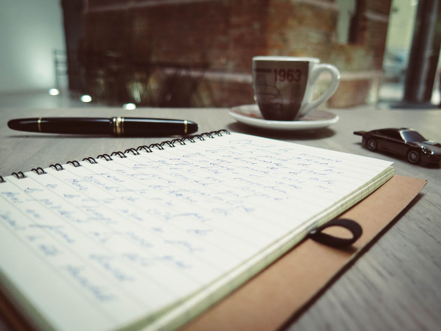 Notebook and coffee on a writing desk
