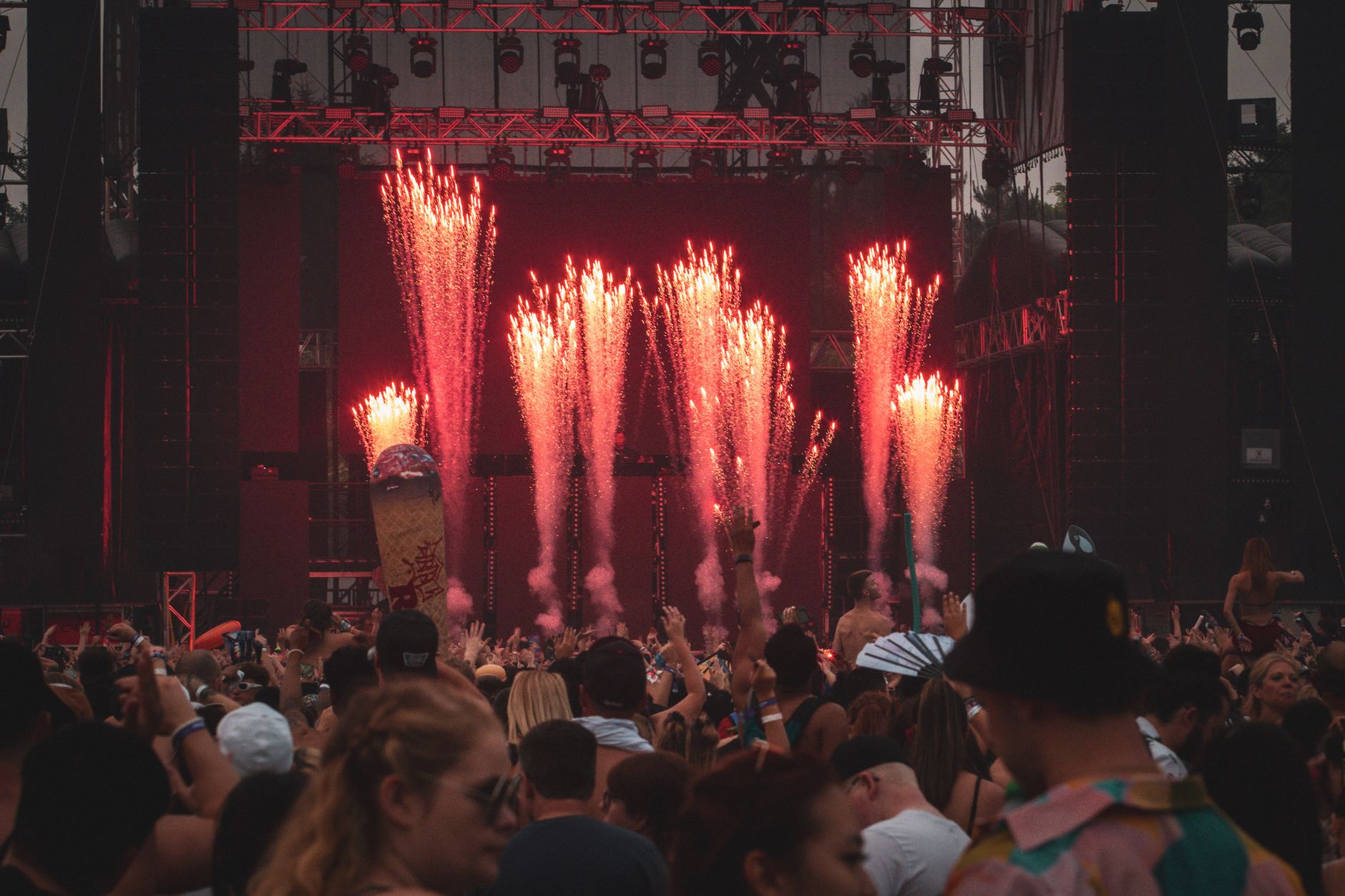 Outdoor concert crowd under a fireworks display