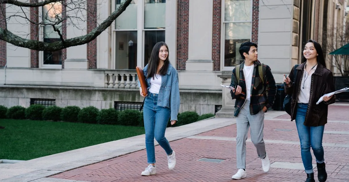 Students walk across a brick university quad between classes