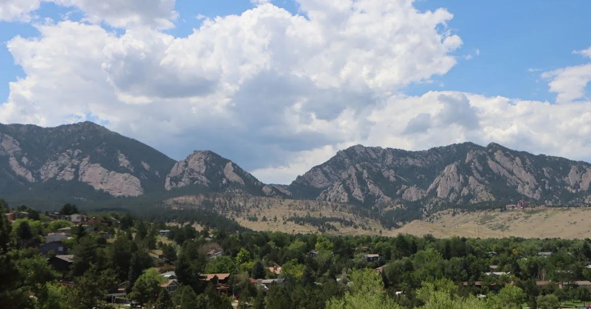 The Flatirons rise above a tree-lined Boulder, Colorado neighborhood near campus