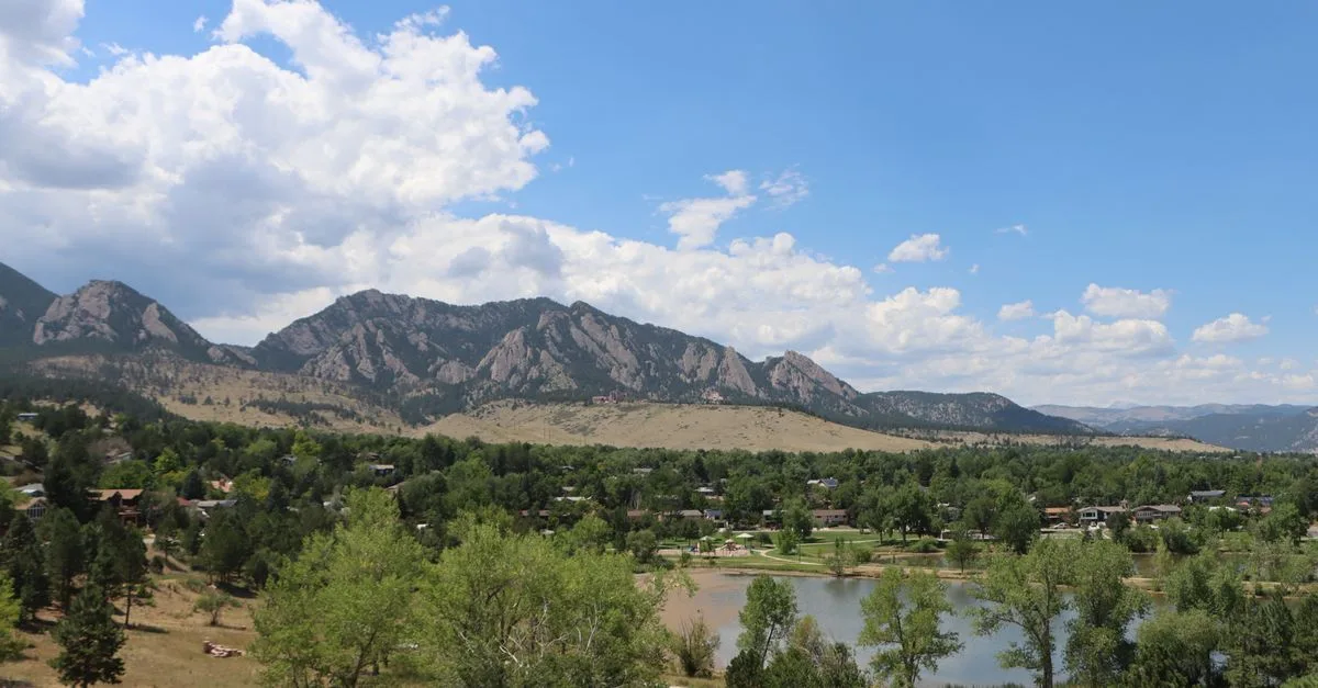 Boulder, Colorado neighborhood with homes, a lake, and the Flatirons behind it