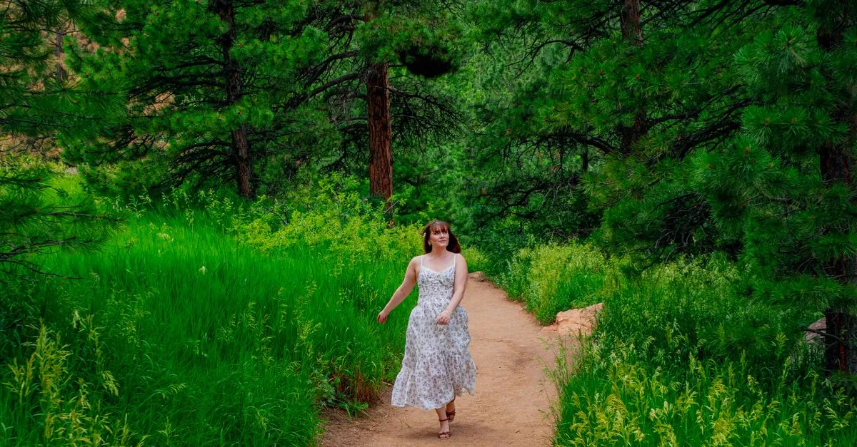A woman walks a ponderosa pine forest trail near Shanahan Ridge in Boulder, Colorado